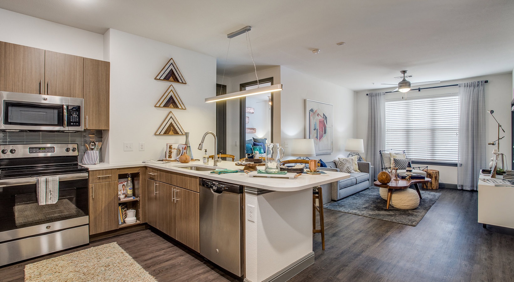 a kitchen and living room area with stainless steel appliances at The Twin Creeks Crossing