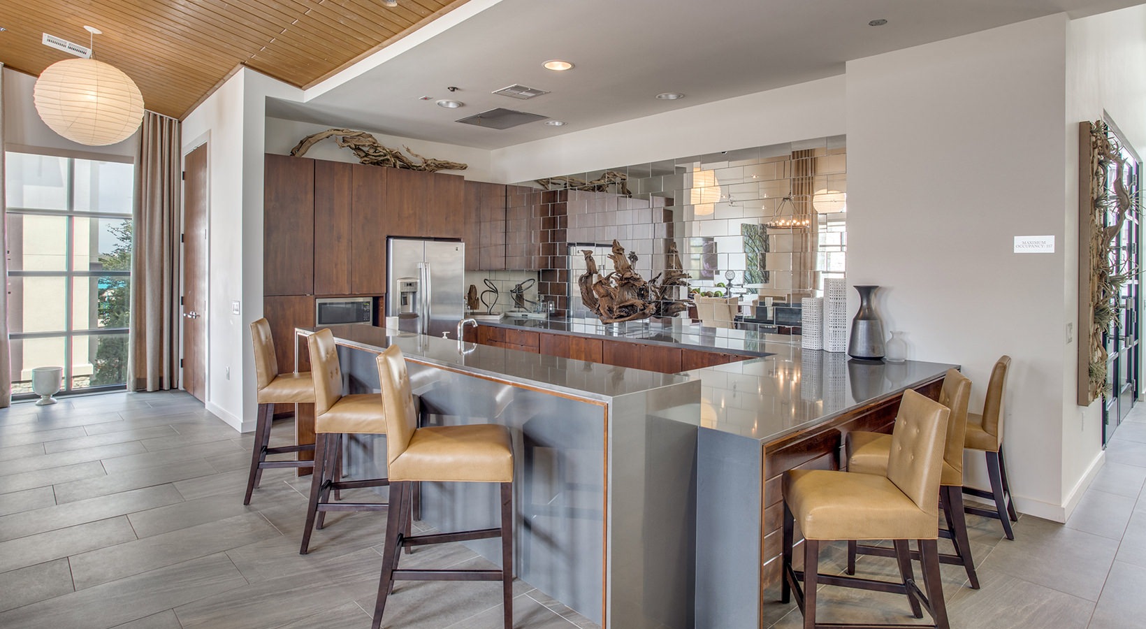 a large kitchen with a bar and chairs at The Twin Creeks Crossing