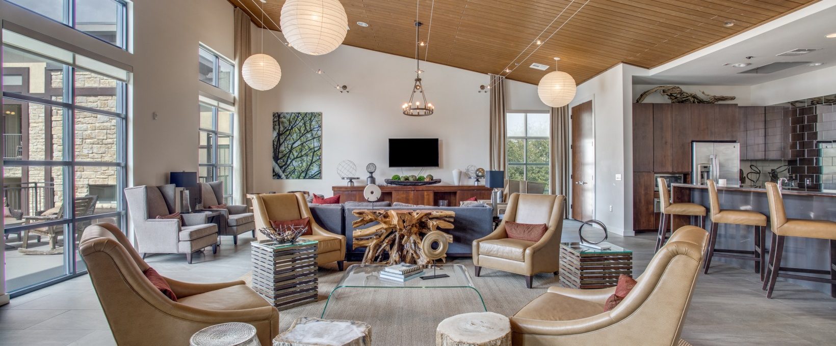 a large open living room with wood ceiling and a fireplace at The Twin Creeks Crossing
