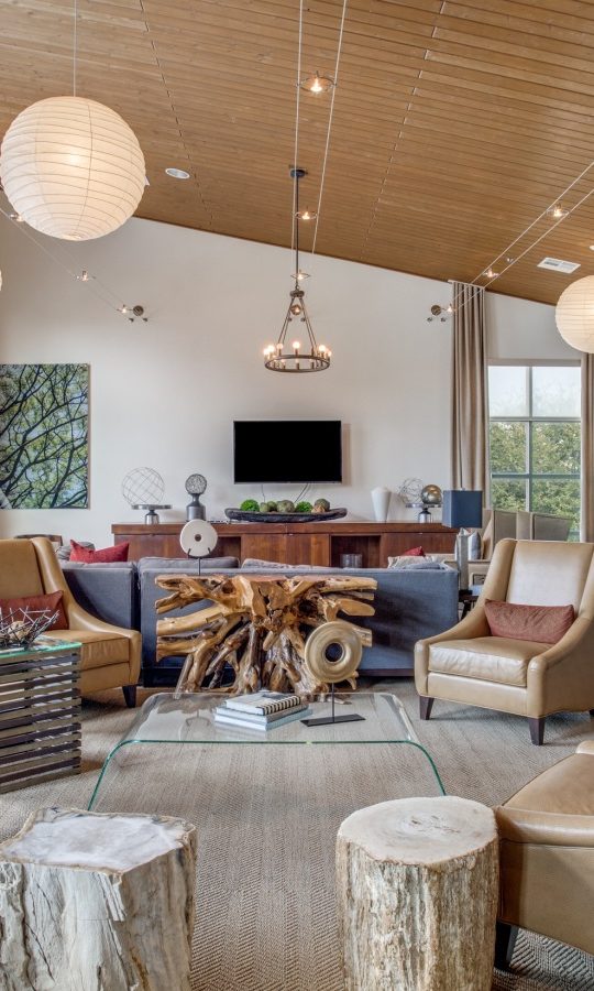 a large open living room with wood ceiling and a fireplace at The Twin Creeks Crossing